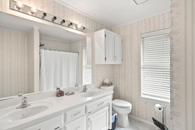 bathroom with a sink, toilet, double vanity, and wallpapered walls