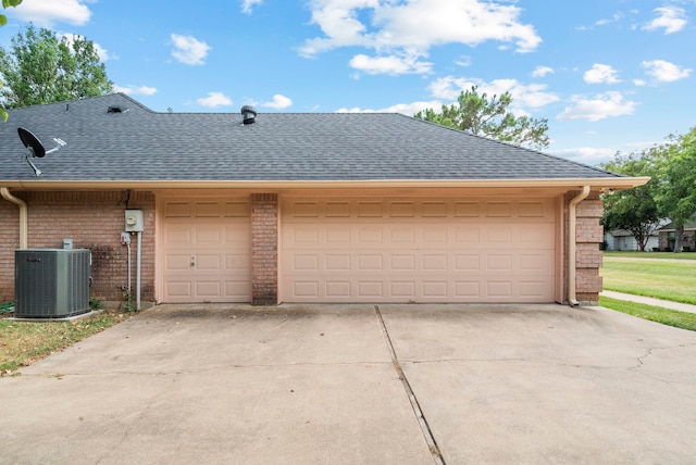 garage featuring cooling unit and driveway