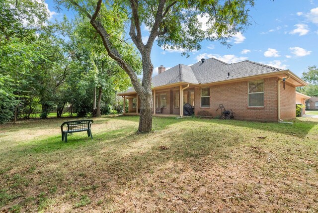 rear view of house featuring a yard