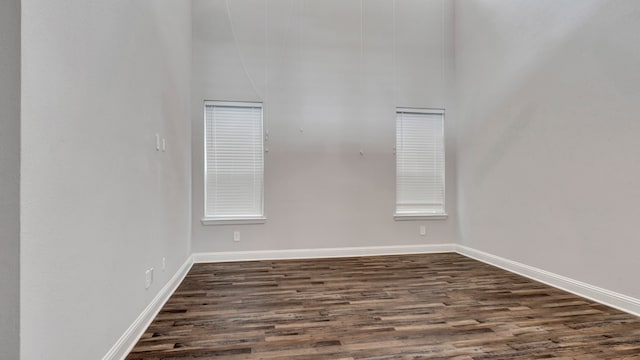 empty room with dark hardwood / wood-style flooring