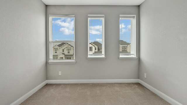 spare room with a healthy amount of sunlight and light colored carpet