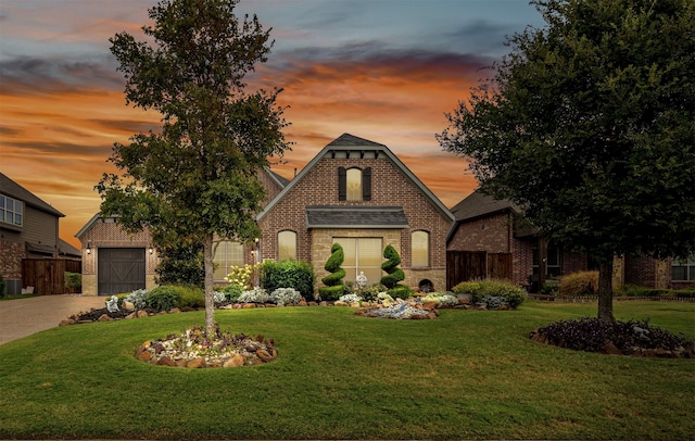 tudor home with a yard and a garage