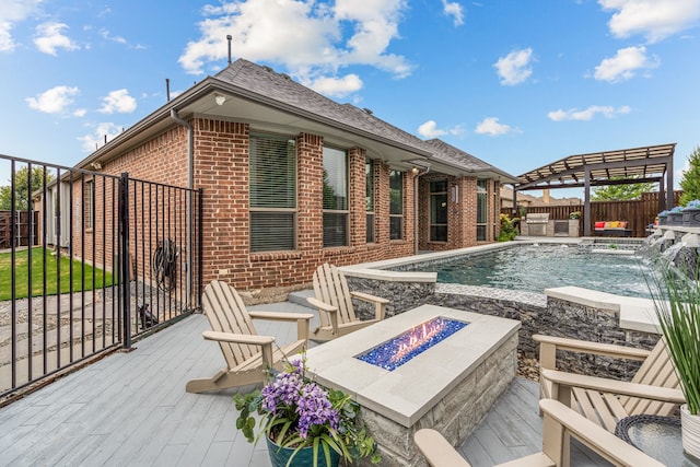 view of pool featuring pool water feature, a deck, and an outdoor fire pit