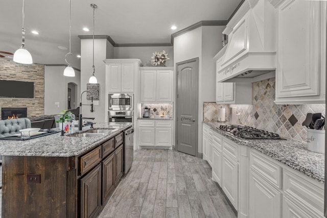 kitchen with premium range hood, white cabinetry, stainless steel appliances, and pendant lighting