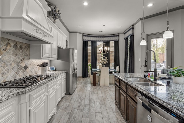 kitchen with white cabinetry, custom range hood, stainless steel appliances, and light stone counters