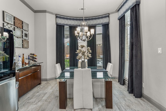 dining room with ornamental molding, a notable chandelier, light hardwood / wood-style floors, and plenty of natural light