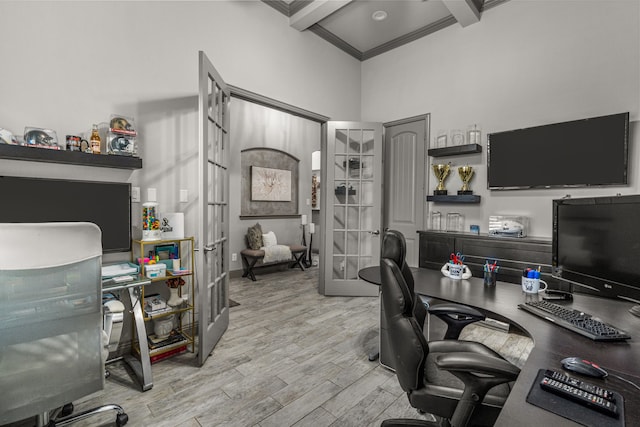 office featuring french doors, a high ceiling, light hardwood / wood-style flooring, beamed ceiling, and ornamental molding