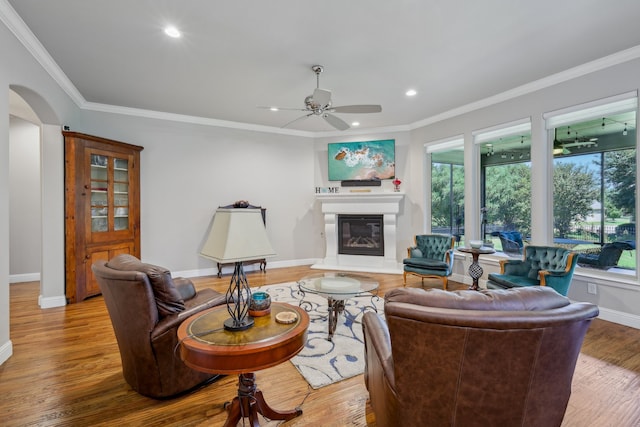 living room featuring ceiling fan, hardwood / wood-style flooring, and ornamental molding