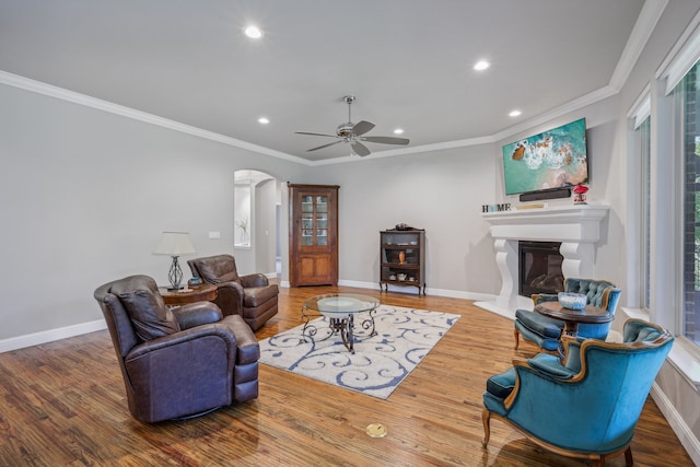 living room featuring a healthy amount of sunlight, ceiling fan, and ornamental molding