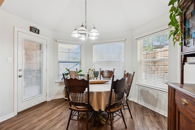 dining space with hardwood / wood-style flooring, a chandelier, and vaulted ceiling