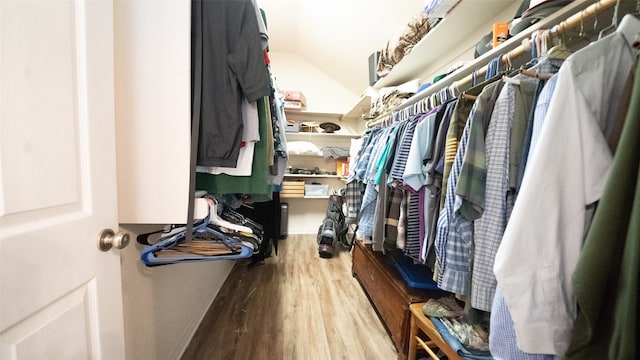 walk in closet with light hardwood / wood-style flooring and lofted ceiling