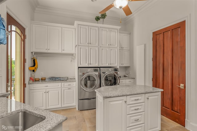 laundry room with crown molding, cabinets, independent washer and dryer, and sink