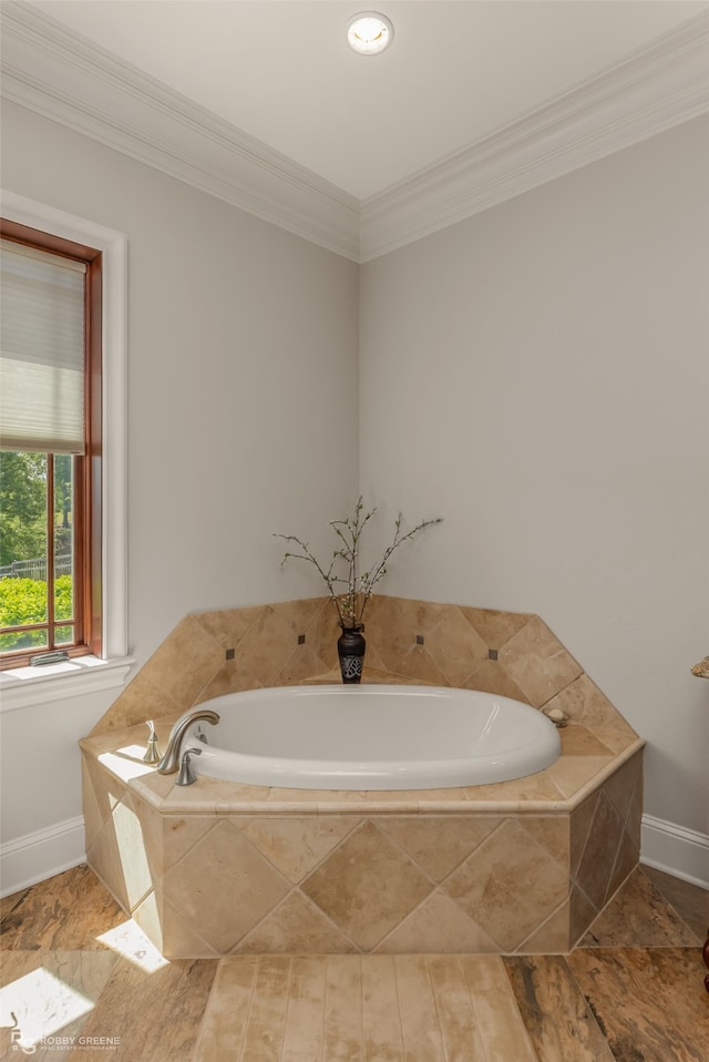 bathroom with wood-type flooring, tiled bath, and ornamental molding