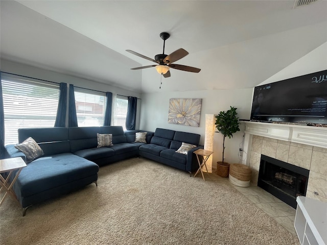 carpeted living room featuring a fireplace, vaulted ceiling, and ceiling fan