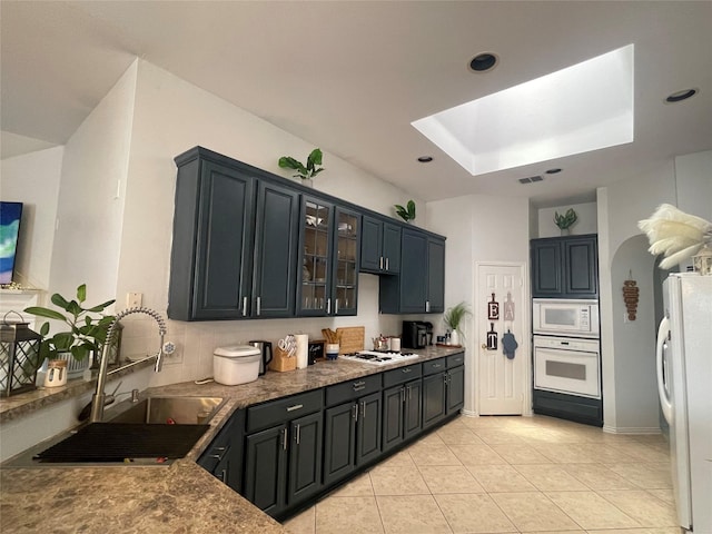 kitchen featuring white appliances, sink, light tile patterned flooring, and tasteful backsplash