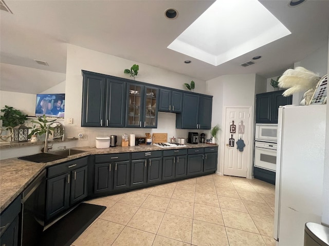 kitchen featuring white appliances, light tile patterned floors, sink, a tray ceiling, and stone countertops