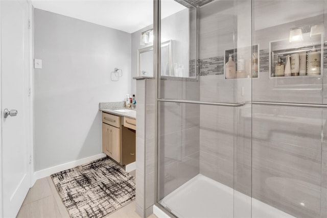 bathroom with tile patterned flooring, vanity, and a shower with shower door