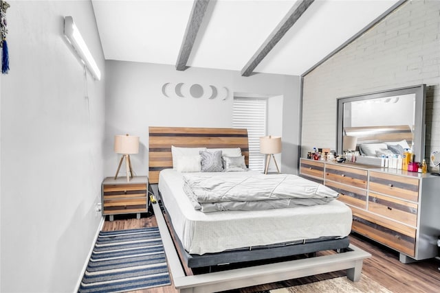 bedroom with light hardwood / wood-style flooring, brick wall, and beamed ceiling