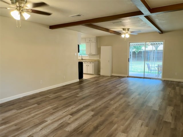 unfurnished living room featuring ceiling fan, beamed ceiling, and wood-type flooring