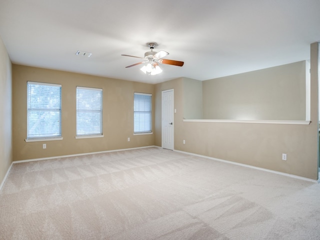 carpeted spare room with ceiling fan