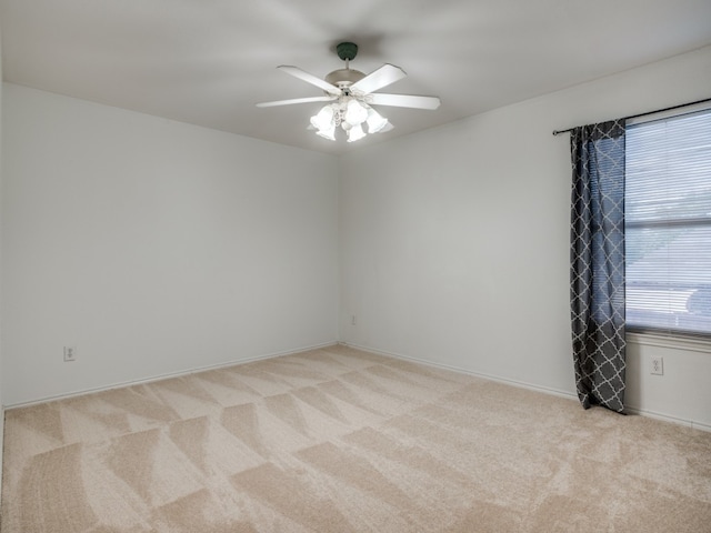 spare room featuring light colored carpet and ceiling fan