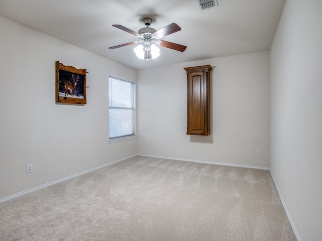 carpeted spare room with ceiling fan