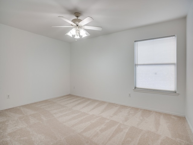 empty room with ceiling fan and light carpet