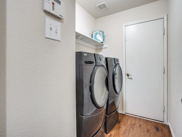 washroom with separate washer and dryer and dark hardwood / wood-style floors