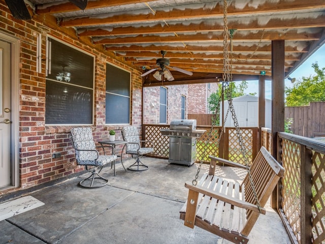 view of patio with area for grilling, ceiling fan, and a shed