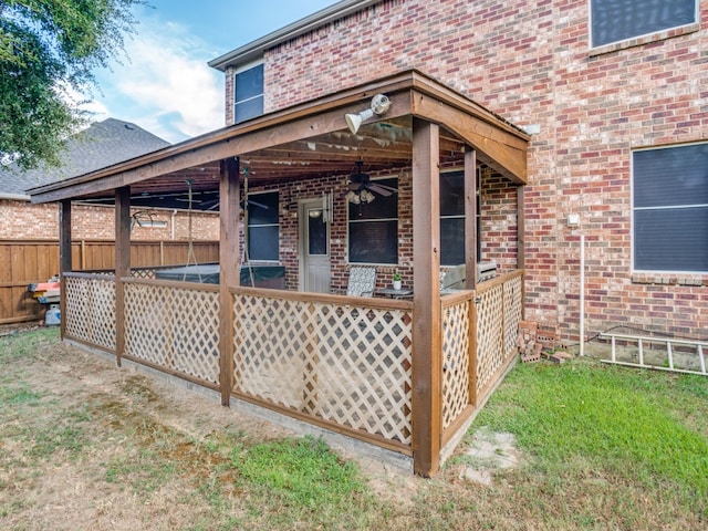 exterior space with ceiling fan and a lawn