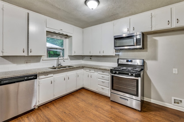 kitchen featuring white cabinets, tasteful backsplash, stainless steel appliances, and sink