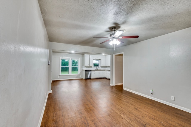 unfurnished living room featuring hardwood / wood-style floors, ceiling fan, sink, and a textured ceiling