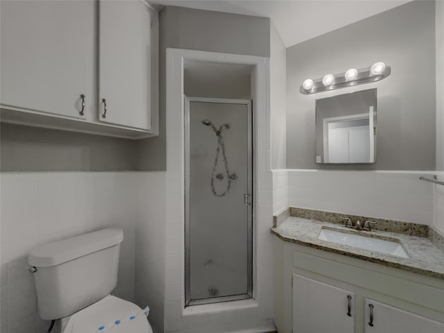 bathroom with vanity, toilet, tile walls, and walk in shower