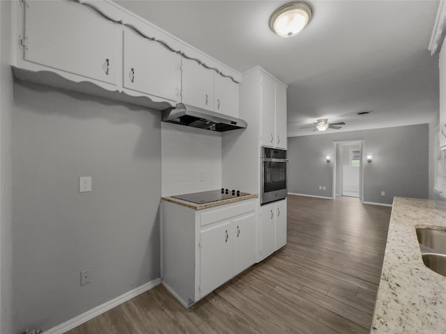 kitchen featuring white cabinets, black electric cooktop, light hardwood / wood-style flooring, and stainless steel oven