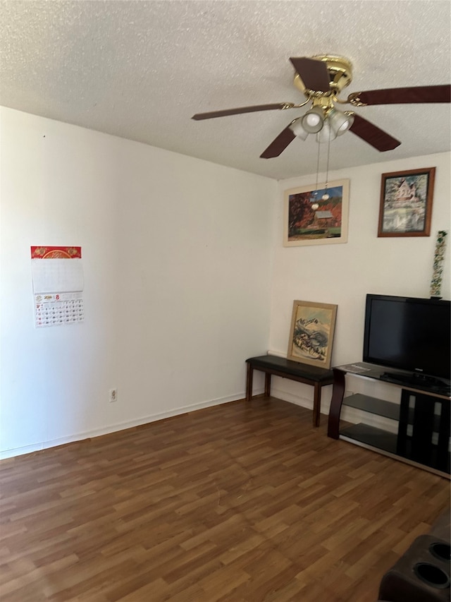 unfurnished living room with a textured ceiling, dark wood-type flooring, and ceiling fan