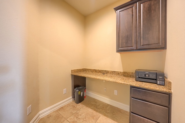 unfurnished office featuring built in study area, baseboards, and light tile patterned floors