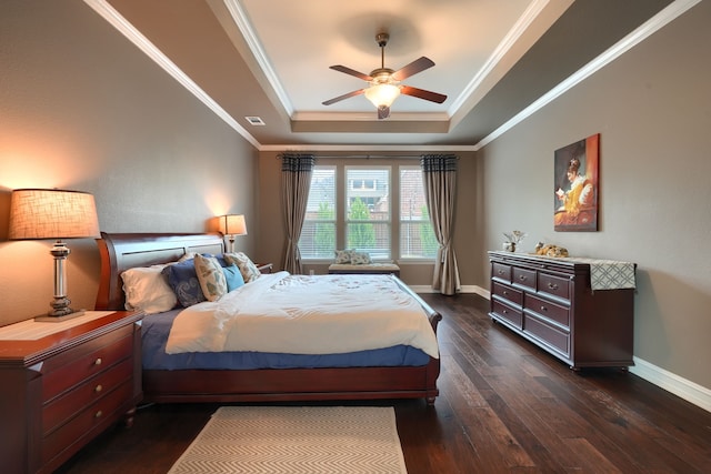 bedroom featuring visible vents, dark wood finished floors, baseboards, a tray ceiling, and crown molding