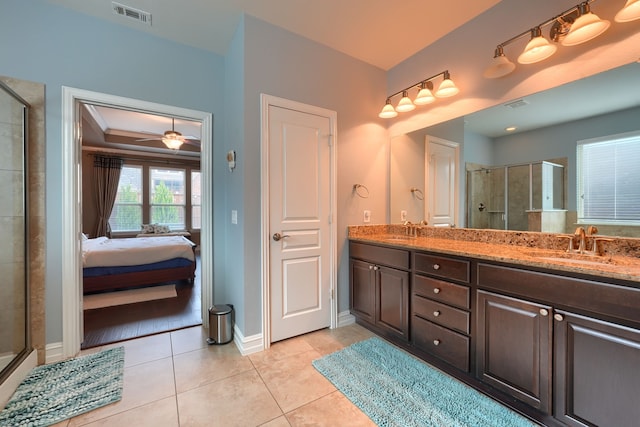 bathroom featuring tile patterned floors, ceiling fan, a shower with door, and vanity