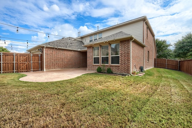 back of house with brick siding, a fenced backyard, a yard, and a patio