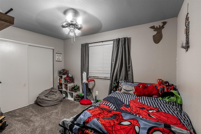 carpeted bedroom with a textured ceiling, a closet, and ceiling fan