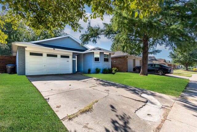 single story home featuring a front lawn and a garage