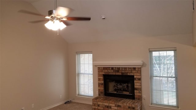 unfurnished living room featuring lofted ceiling, ceiling fan, a fireplace, and carpet