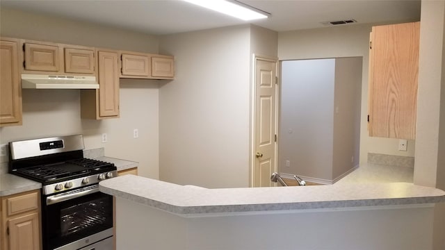 kitchen with kitchen peninsula, light brown cabinets, and gas stove