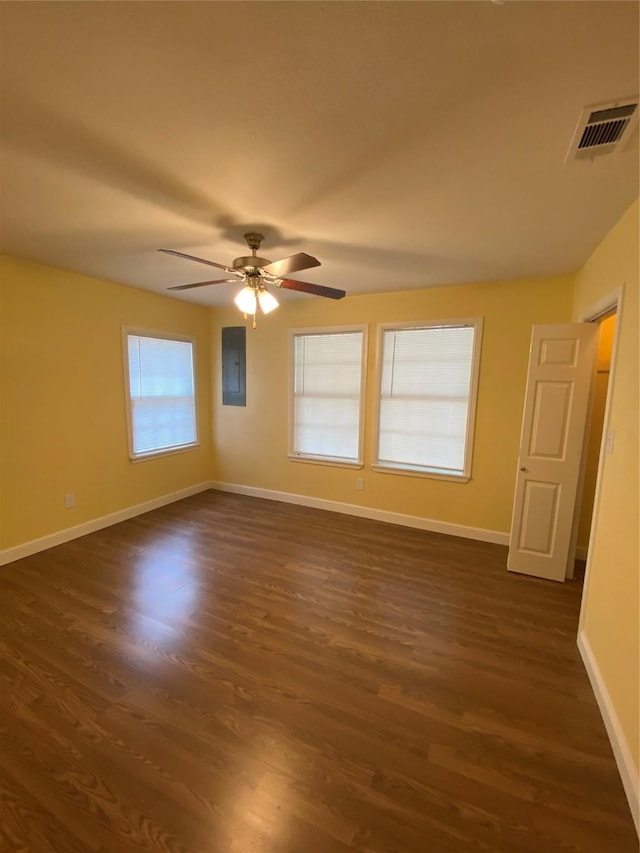 spare room with electric panel, dark hardwood / wood-style floors, and ceiling fan