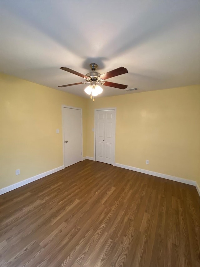 spare room featuring dark hardwood / wood-style flooring and ceiling fan