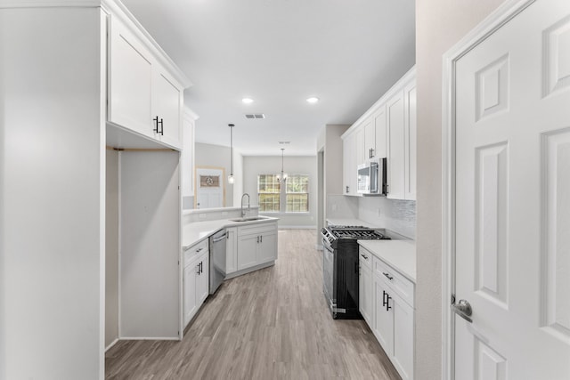 kitchen featuring pendant lighting, sink, light hardwood / wood-style flooring, stainless steel appliances, and white cabinets