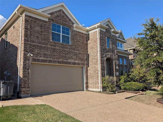 traditional home featuring an attached garage, concrete driveway, and brick siding