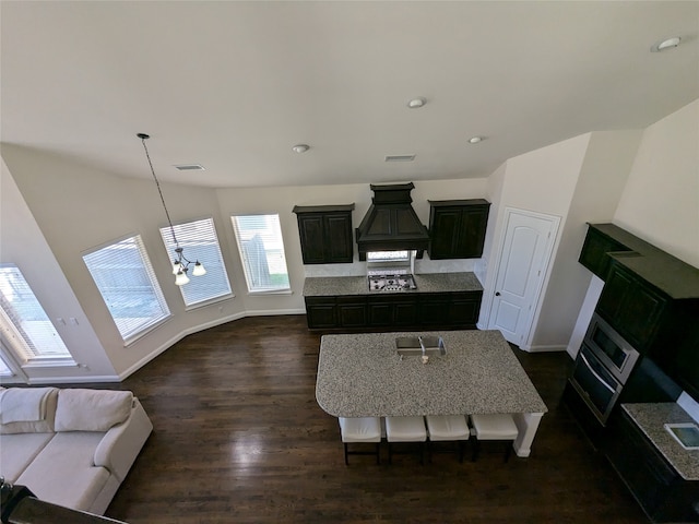 living room with dark wood-type flooring, a fireplace, and a chandelier