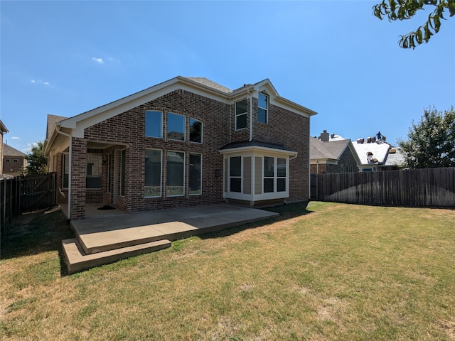 rear view of house with a lawn and a patio