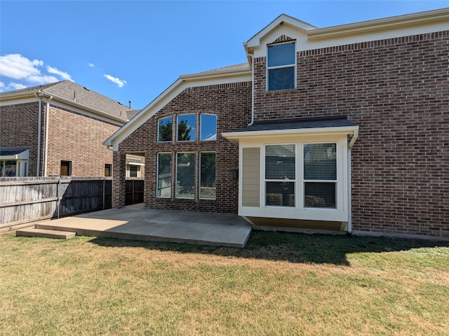 rear view of house with a lawn and a patio area